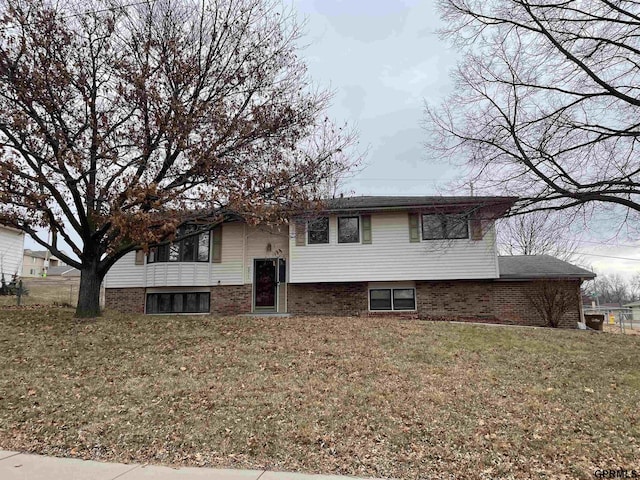 bi-level home with a front lawn and brick siding