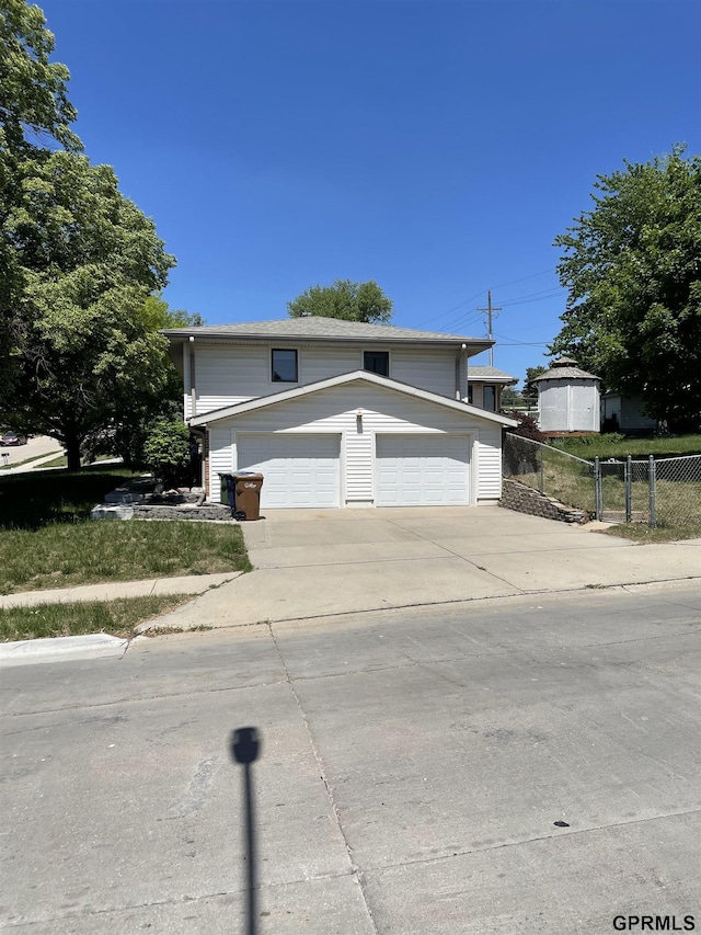 view of front facade with a garage, fence, and driveway
