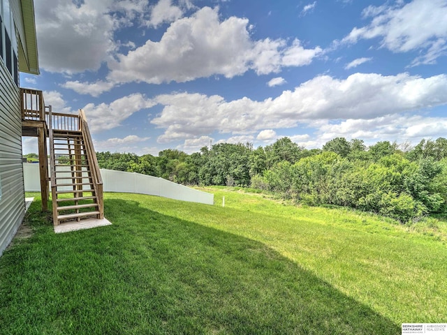 view of yard featuring stairway and a view of trees