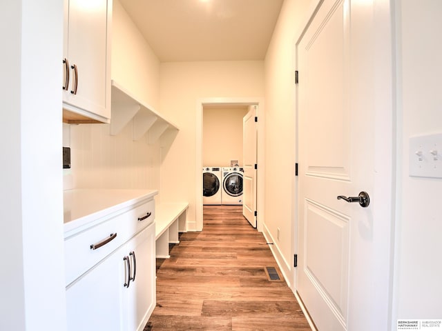 laundry room featuring independent washer and dryer and light wood-style floors