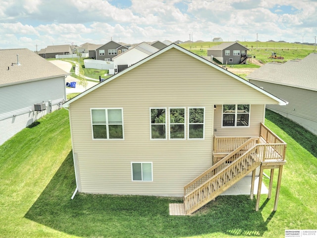 back of house with stairway, a deck, a yard, and a residential view