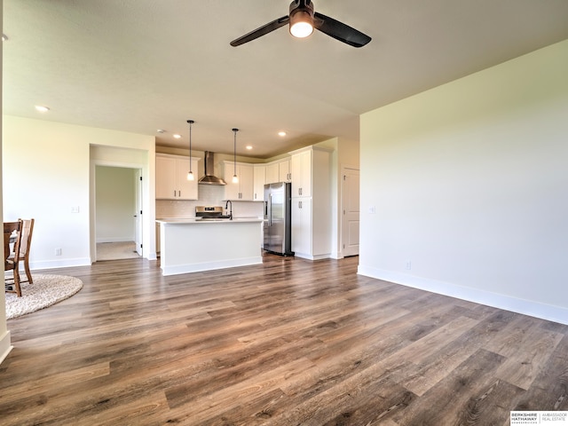 unfurnished living room with recessed lighting, dark wood-style floors, a ceiling fan, and baseboards