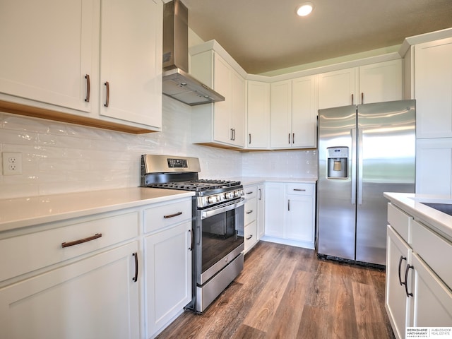 kitchen featuring stainless steel appliances, wall chimney range hood, light countertops, dark wood-style flooring, and white cabinets