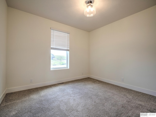 carpeted empty room with baseboards