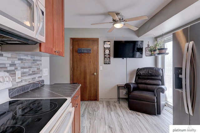 13253 Josephine St, Omaha, NE 68138 - kitchen with white microwave, electric range, stainless steel fridge with ice dispenser, tile countertops, and tasteful backsplash