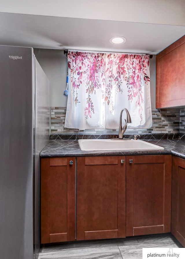 13253 Josephine St, Omaha, NE 68138 - kitchen with freestanding refrigerator, a sink, tasteful backsplash, dark countertops, and recessed lighting