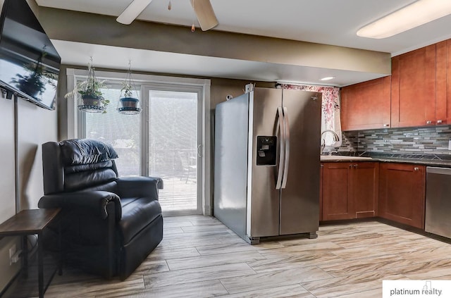 13253 Josephine St, Omaha, NE 68138 - kitchen with stainless steel appliances, a sink, decorative backsplash, dark countertops, and ceiling fan
