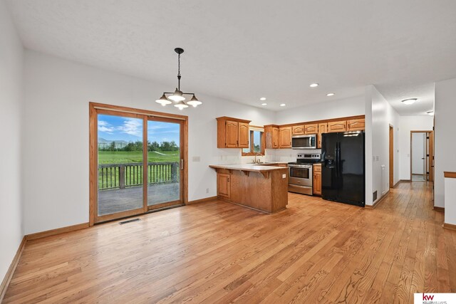 60050 Karns Rd, Pacific Junction, IA 51561 - kitchen featuring appliances with stainless steel finishes, a peninsula, a sink, light wood-type flooring, and recessed lighting