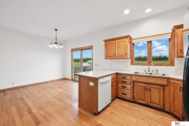 60050 Karns Rd, Pacific Junction, IA 51561 - kitchen featuring white dishwasher, a sink, a peninsula, decorative backsplash, and light countertops
