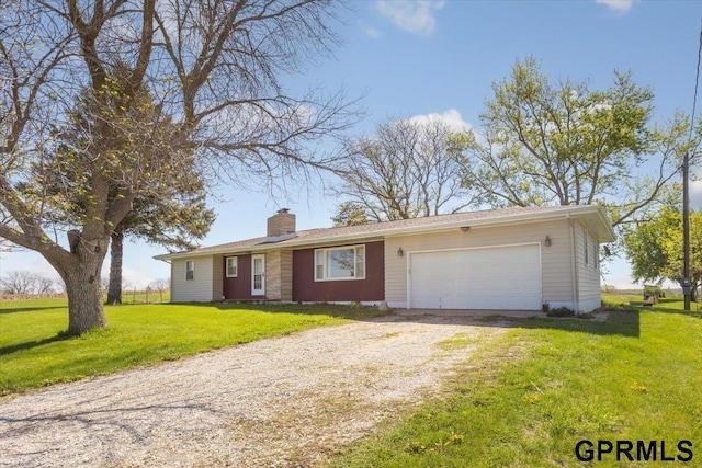 single story home with driveway, a chimney, an attached garage, and a front lawn