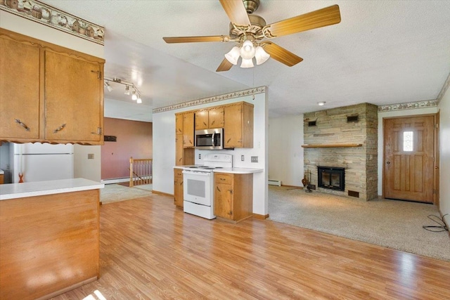 kitchen featuring white appliances, baseboards, a fireplace, light wood-style flooring, and light countertops