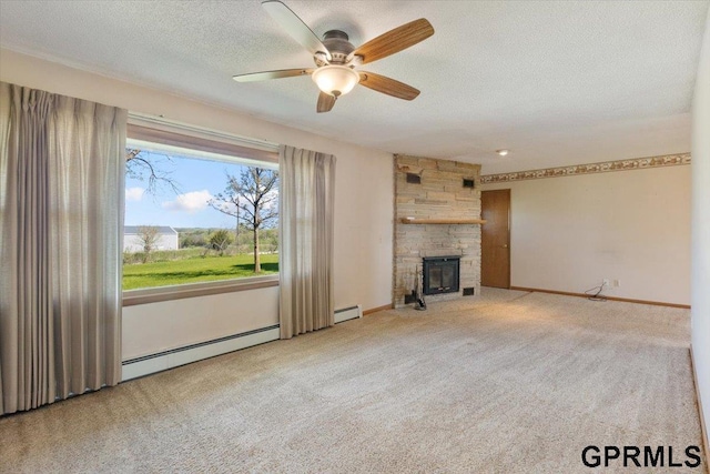 unfurnished living room with baseboard heating, carpet flooring, a stone fireplace, a ceiling fan, and a textured ceiling