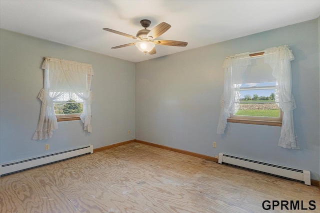 empty room featuring baseboard heating, a ceiling fan, and baseboards