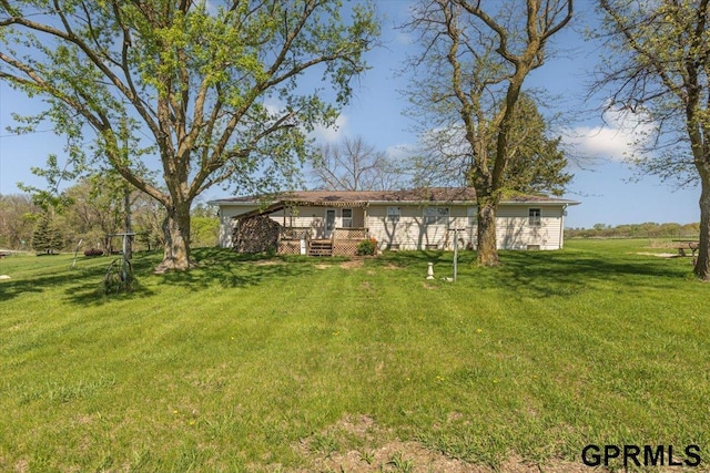 view of green lawn featuring a deck
