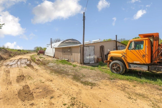 rear view of property featuring an outdoor structure