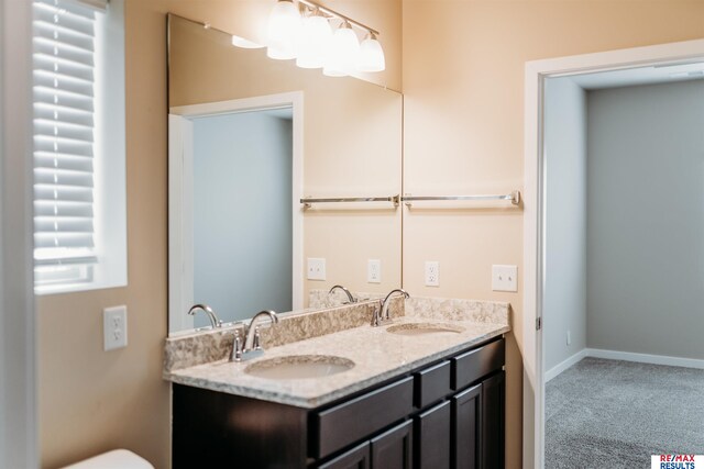 7202 N 167th Ave, Bennington, NE 68007 - full bathroom with double vanity, baseboards, and toilet