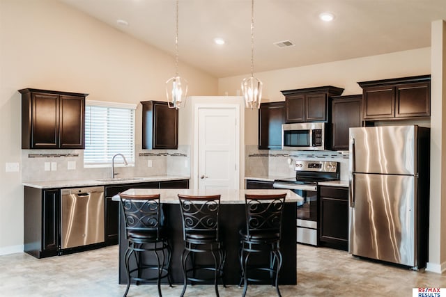 7202 N 167th Ave, Bennington, NE 68007 - kitchen with stainless steel appliances, a sink, backsplash, a center island, and dark brown cabinets