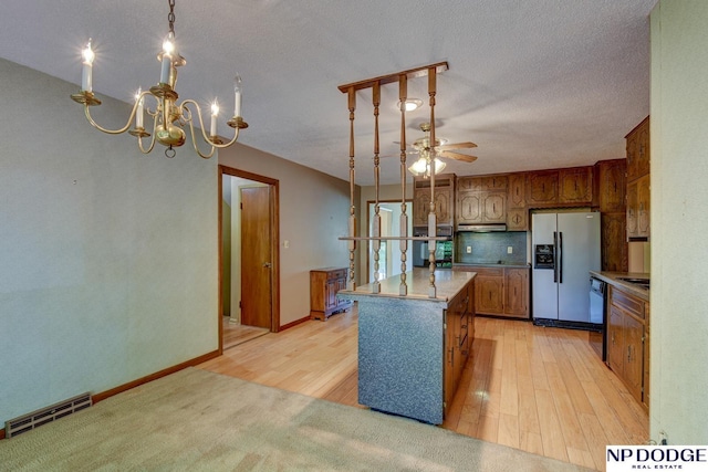 2352 Lincoln St, Blair, NE 68008 - kitchen featuring refrigerator with ice dispenser, a kitchen island, brown cabinetry, a chandelier, and light wood finished floors