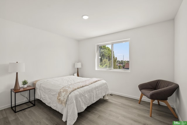 bedroom featuring wood finished floors, baseboards, and recessed lighting