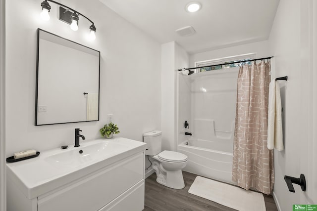 bathroom featuring wood finished floors, toilet, shower / bath combination with curtain, and vanity