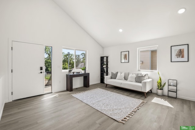 living area featuring high vaulted ceiling, wood finished floors, recessed lighting, and baseboards