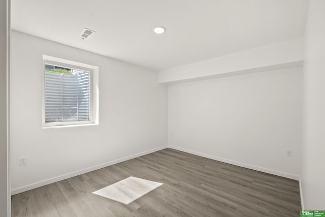 unfurnished room with wood finished floors, baseboards, and recessed lighting