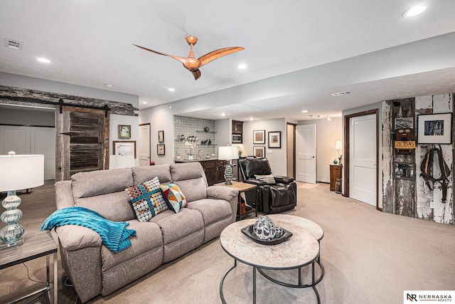 2705 N 189th St, Omaha, NE 68022 - carpeted living area featuring a barn door, recessed lighting, bar, and a ceiling fan