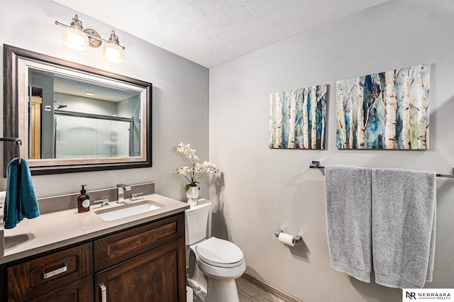 2705 N 189th St, Omaha, NE 68022 - bathroom with toilet, vanity, an enclosed shower, a textured ceiling, and baseboards
