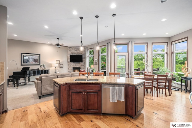 2705 N 189th St, Omaha, NE 68022 - kitchen featuring dishwasher, a sink, a stone fireplace, light wood-style flooring, and ceiling fan