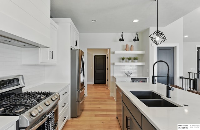 5508 N 208th St, Elkhorn, NE 68022 - kitchen with appliances with stainless steel finishes, a sink, wall chimney exhaust hood, light countertops, and white cabinetry