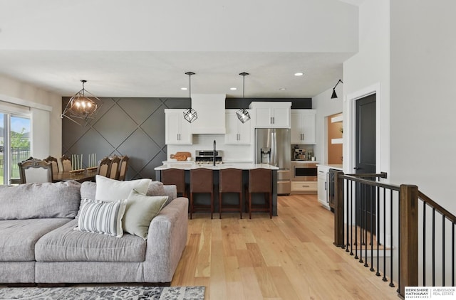 5508 N 208th St, Elkhorn, NE 68022 - living area with light wood-type flooring, a chandelier, an accent wall, and recessed lighting