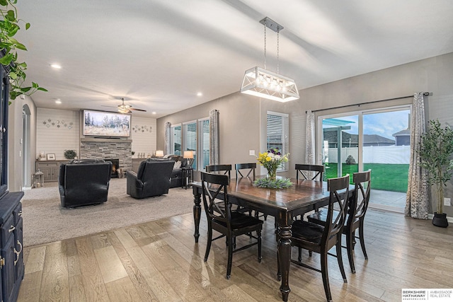 17176 Summit St, Bennington, NE 68007 - dining room with light wood finished floors, a stone fireplace, a ceiling fan, and recessed lighting
