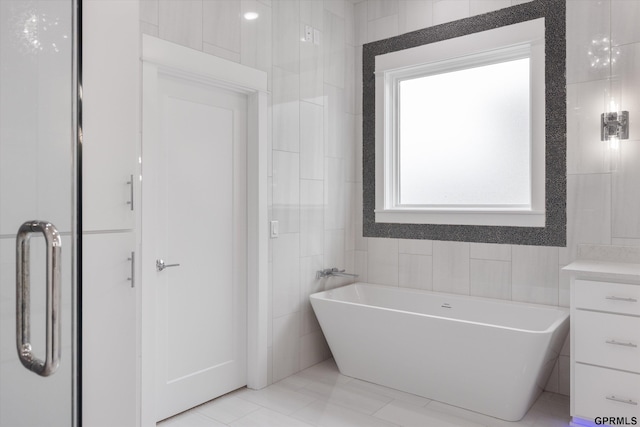 12604 N 178th Cir, Bennington, NE 68007 - bathroom with tile walls, a freestanding tub, vanity, and tile patterned floors