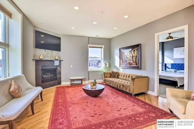 210 S 16th St S Unit 918, Omaha, NE 68102 - living area with light wood-style flooring, a tiled fireplace, recessed lighting, baseboards, and a ceiling fan