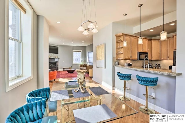 210 S 16th St S Unit 918, Omaha, NE 68102 - kitchen featuring black microwave, pendant lighting, open floor plan, recessed lighting, and a tile fireplace