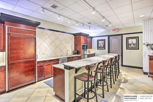 210 S 16th St S Unit 918, Omaha, NE 68102 - kitchen featuring dark brown cabinets, rail lighting, stainless steel dishwasher, light tile patterned floors, and a center island