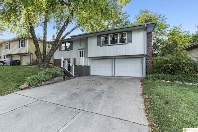 14618 Holmes St, Omaha, NE 68137 - split foyer home with an attached garage, a chimney, concrete driveway, a front yard, and brick siding