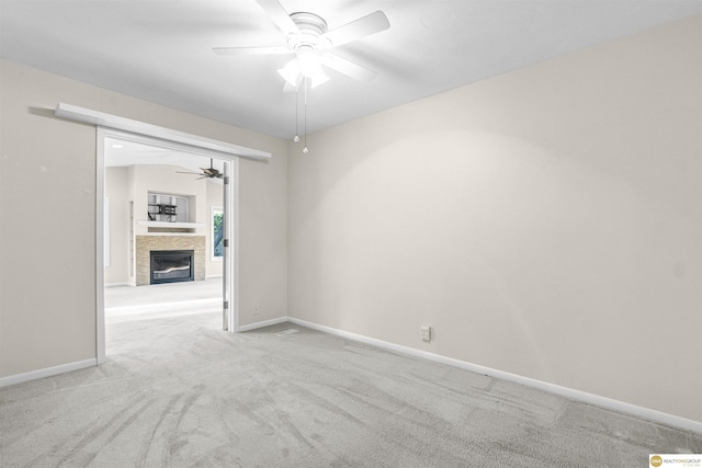 14618 Holmes St, Omaha, NE 68137 - spare room with a ceiling fan, carpet floors, a glass covered fireplace, and baseboards