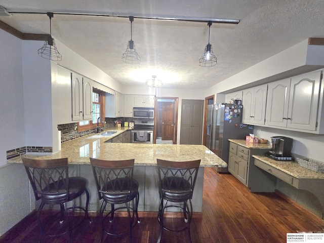 1924 W 8th Ave, Plattsmouth, NE 68048 - kitchen featuring appliances with stainless steel finishes, a sink, a peninsula, dark wood-style flooring, and a breakfast bar area