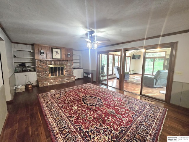 1924 W 8th Ave, Plattsmouth, NE 68048 - living area with wood-type flooring, a textured ceiling, a brick fireplace, ceiling fan, and built in shelves