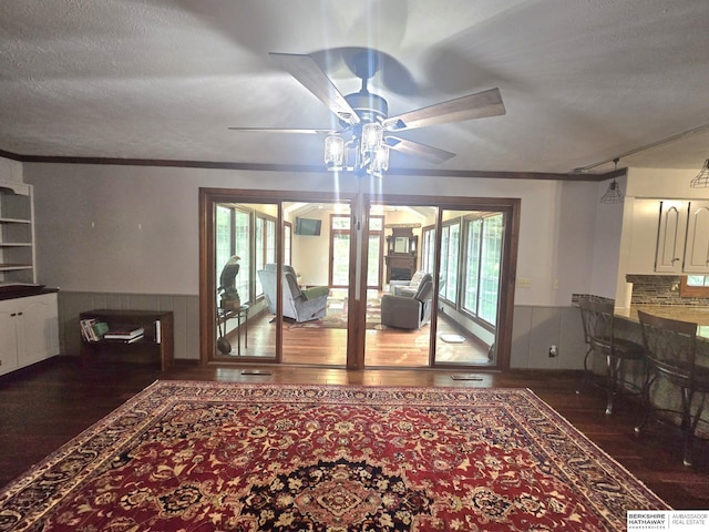 1924 W 8th Ave, Plattsmouth, NE 68048 - dining area featuring wood finished floors, a ceiling fan, a wainscoted wall, crown molding, and a textured ceiling