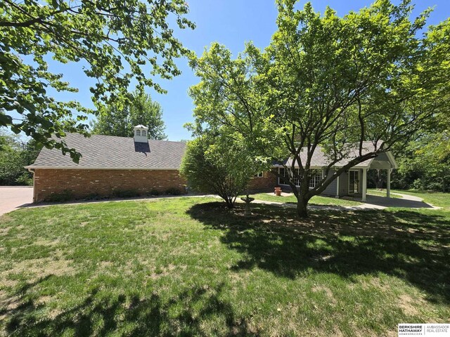1924 W 8th Ave, Plattsmouth, NE 68048 - view of property exterior with a yard, brick siding, a chimney, and roof with shingles