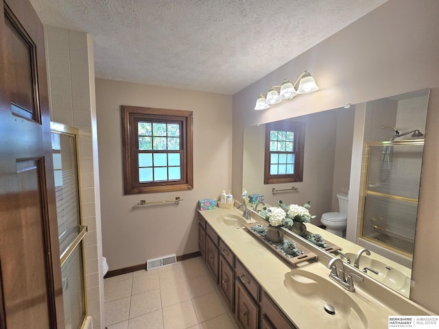 1924 W 8th Ave, Plattsmouth, NE 68048 - full bath with toilet, plenty of natural light, a shower with door, double vanity, and a textured ceiling