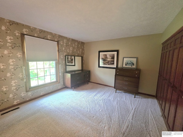 1924 W 8th Ave, Plattsmouth, NE 68048 - unfurnished bedroom with wallpapered walls, carpet flooring, and baseboards