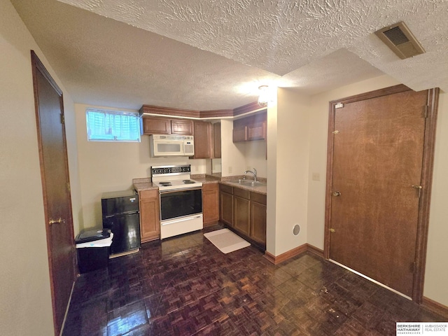 1924 W 8th Ave, Plattsmouth, NE 68048 - kitchen with white appliances, baseboards, a textured ceiling, and a sink