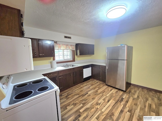 1924 W 8th Ave, Plattsmouth, NE 68048 - kitchen with white appliances, a sink, dark brown cabinets, light wood finished floors, and light countertops