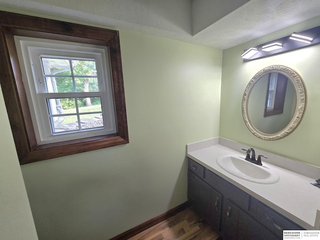 1924 W 8th Ave, Plattsmouth, NE 68048 - bathroom with vanity, wood finished floors, baseboards, and a textured ceiling