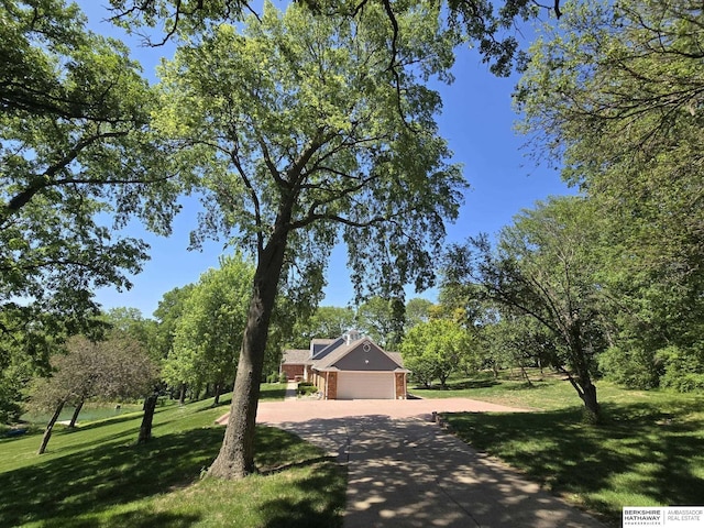 1924 W 8th Ave, Plattsmouth, NE 68048 - view of front of house featuring concrete driveway, a front lawn, an attached garage, and brick siding
