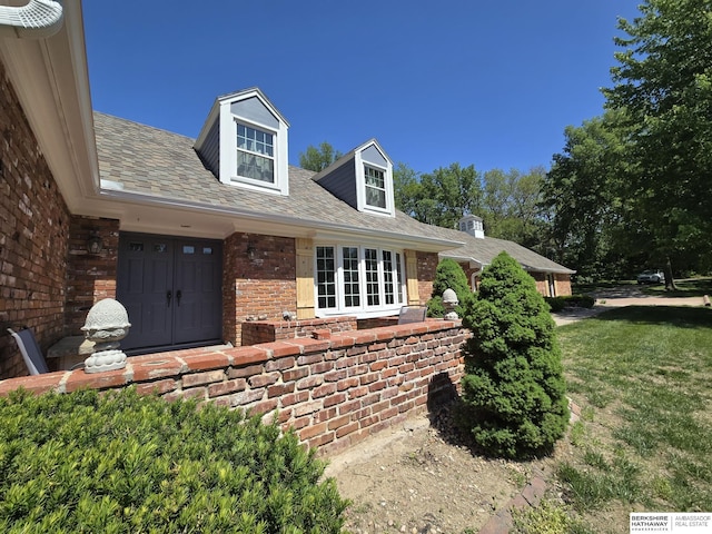 1924 W 8th Ave, Plattsmouth, NE 68048 - view of exterior entry with brick siding, a lawn, and french doors
