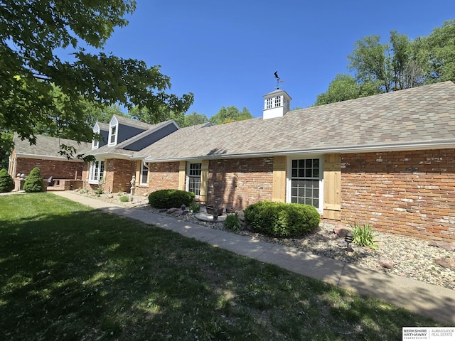 1924 W 8th Ave, Plattsmouth, NE 68048 - rear view of house featuring a yard, a shingled roof, and brick siding